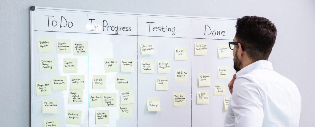 Businessman Looking At Adhesive Note On Board