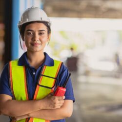 Portrait Indian woman worker supervisor smart confident look with engineer safety suit work in large factory warehouse industry